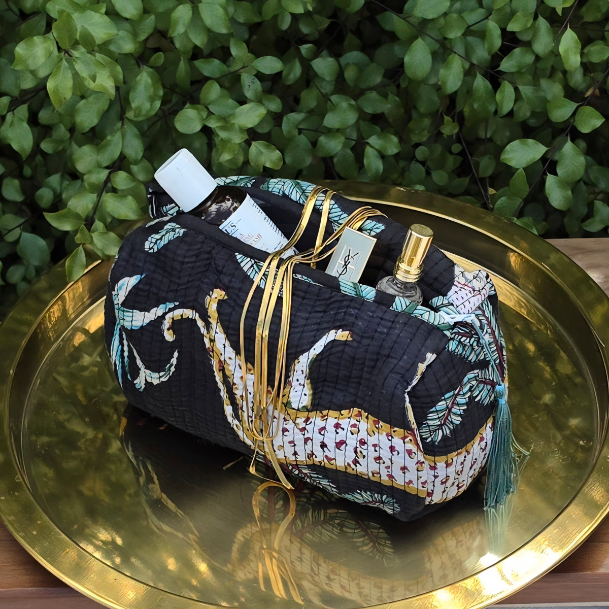black jungle print makeup bag with tassles and waterproof lining and pockets with products