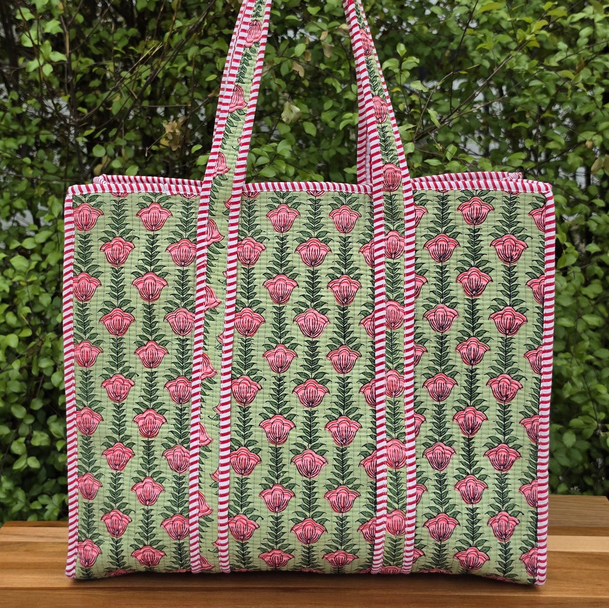 pink flowers in pistachio green background quilted cotton tote bag reversible machine washable with pockets lifestyle shot