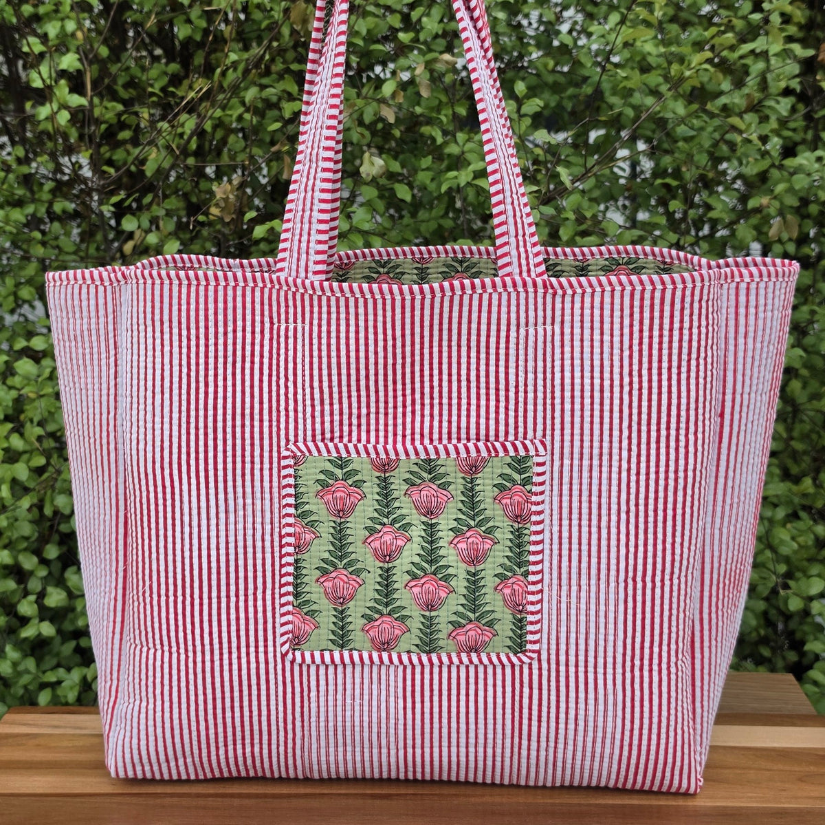 pink flowers in pistachio green background quilted cotton tote bag reversible machine washable with pockets reverse lifestyle shot