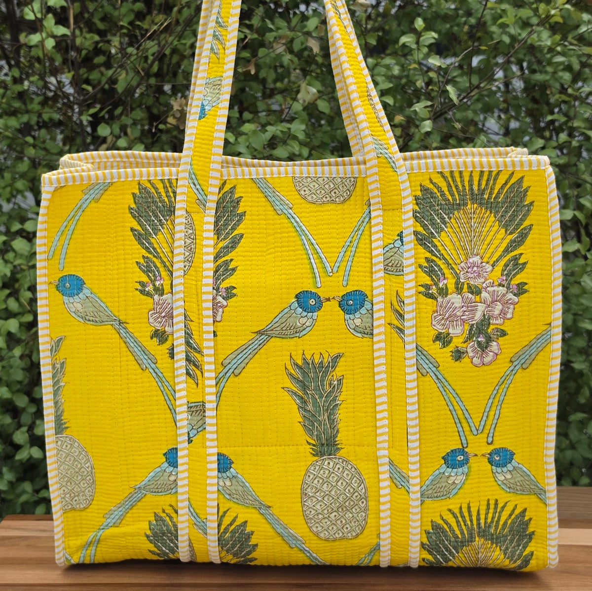yellow and blue birds and fruits pattern quilted cotton tote bag reversible machine washable with pockets lifestyle image